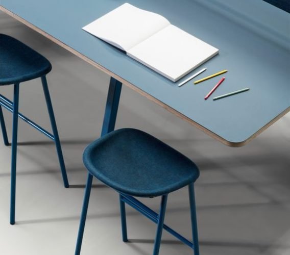 Coworking desk with a notebook and blue stools