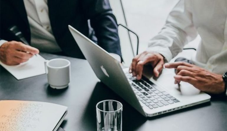 Two people working together on a laptop